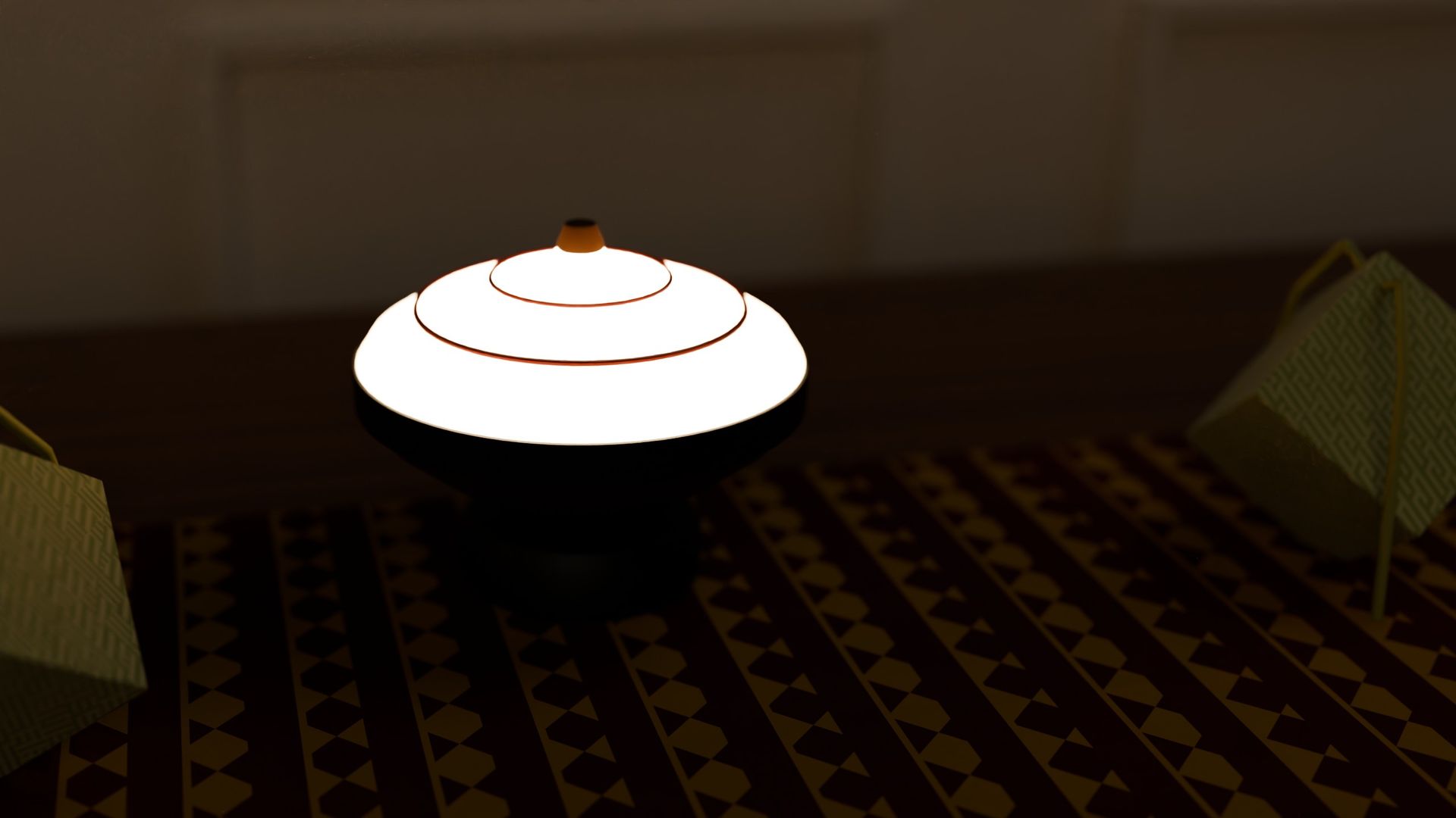 GASING cordless lamp switched on, on a patterned runner with woven ketupat beside it