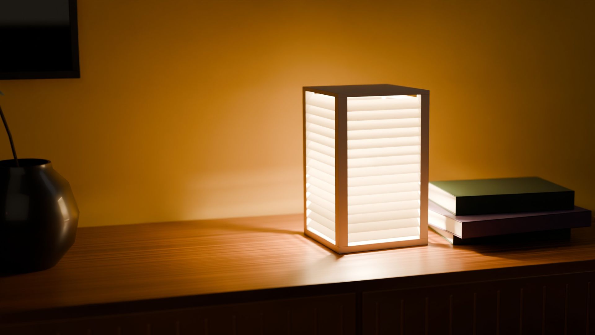 BIDAI table lamp switched on, on a wooden sideboard at night