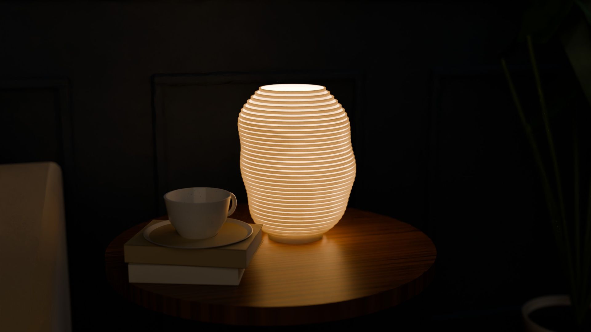 KONTUR table lamp switched on, on a round side table with a cup and books