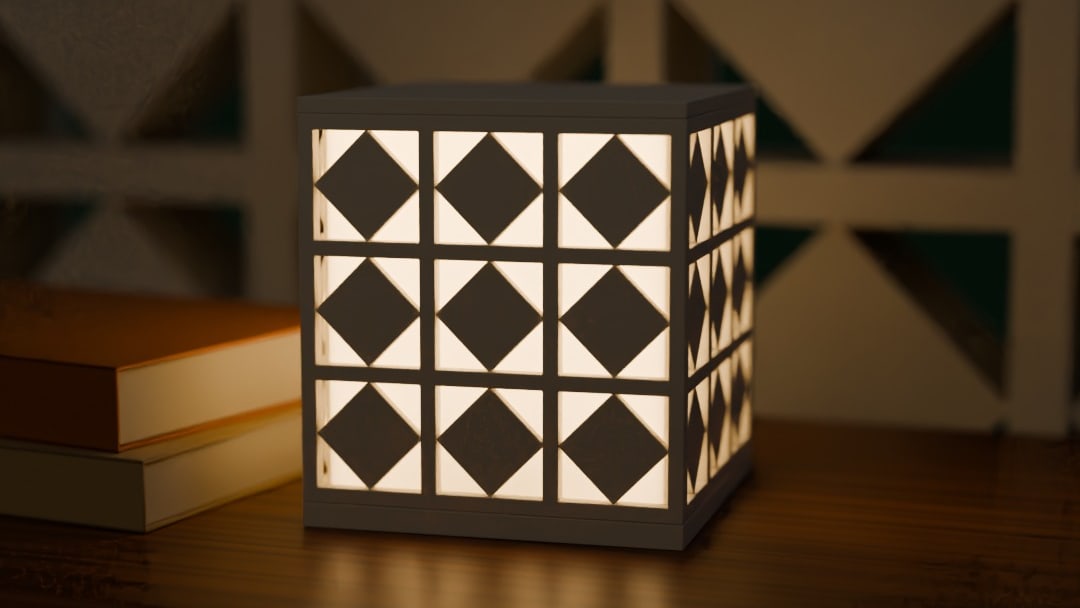 ANGIN cordless lamp in bone white, switched on, on a teak console against a breeze-block wall at night
