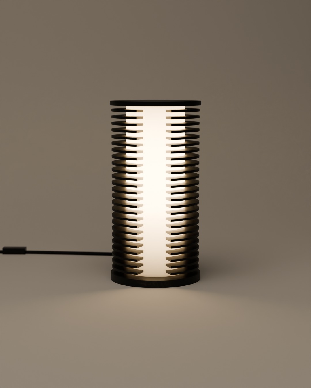 COLUMN table lamp in graphite, switched on, on a plain studio background