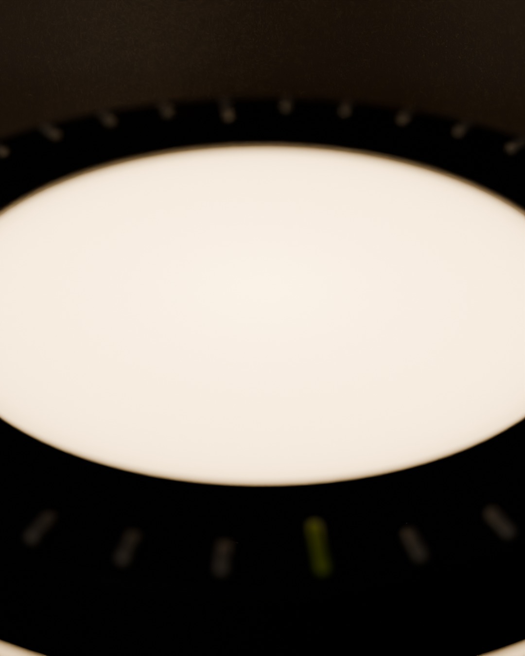 Close-up of the DIAL cordless lamp in graphite, switched on, on a work desk, dial ring, 36 ticks, the lime tick