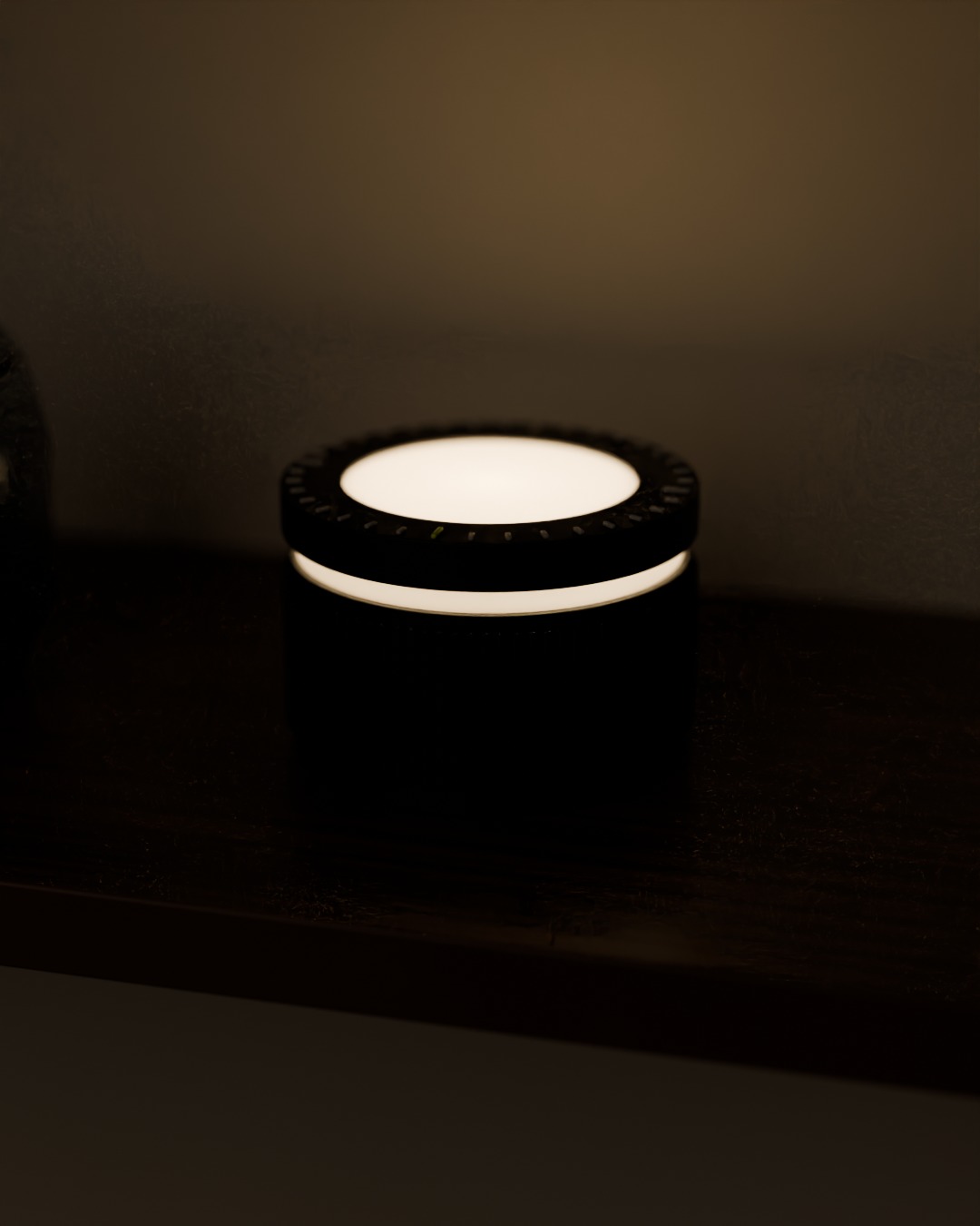 DIAL cordless lamp in graphite, switched on, on a bookshelf