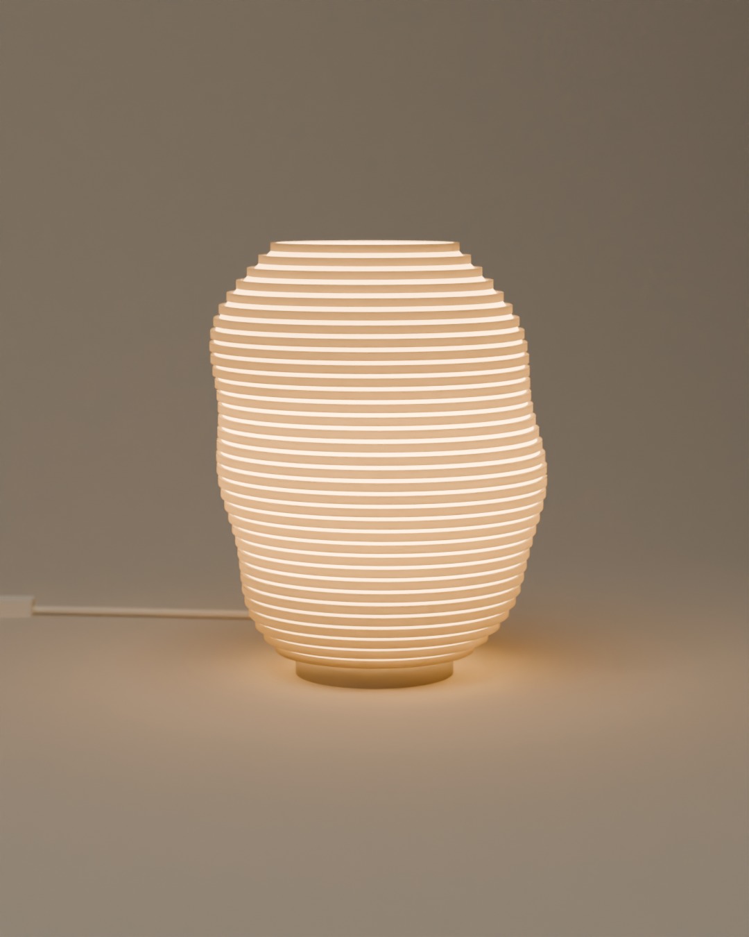KONTUR table lamp in bone white, switched on, on a plain studio background