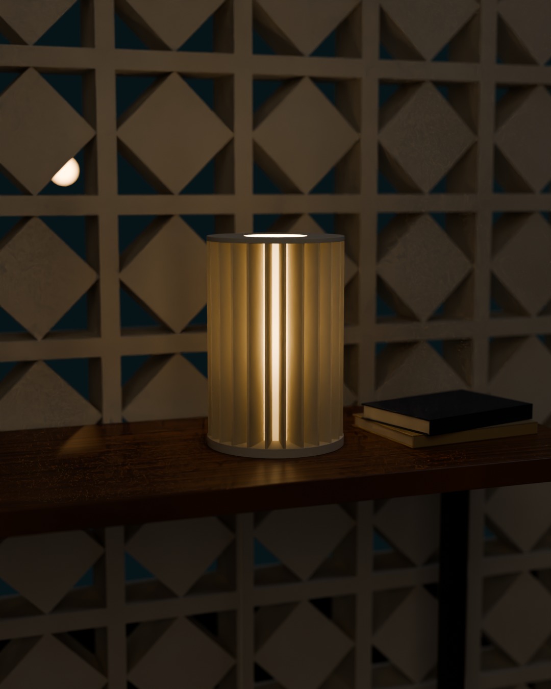 SIRIP table lamp in bone white, switched on, against a breeze-block wall