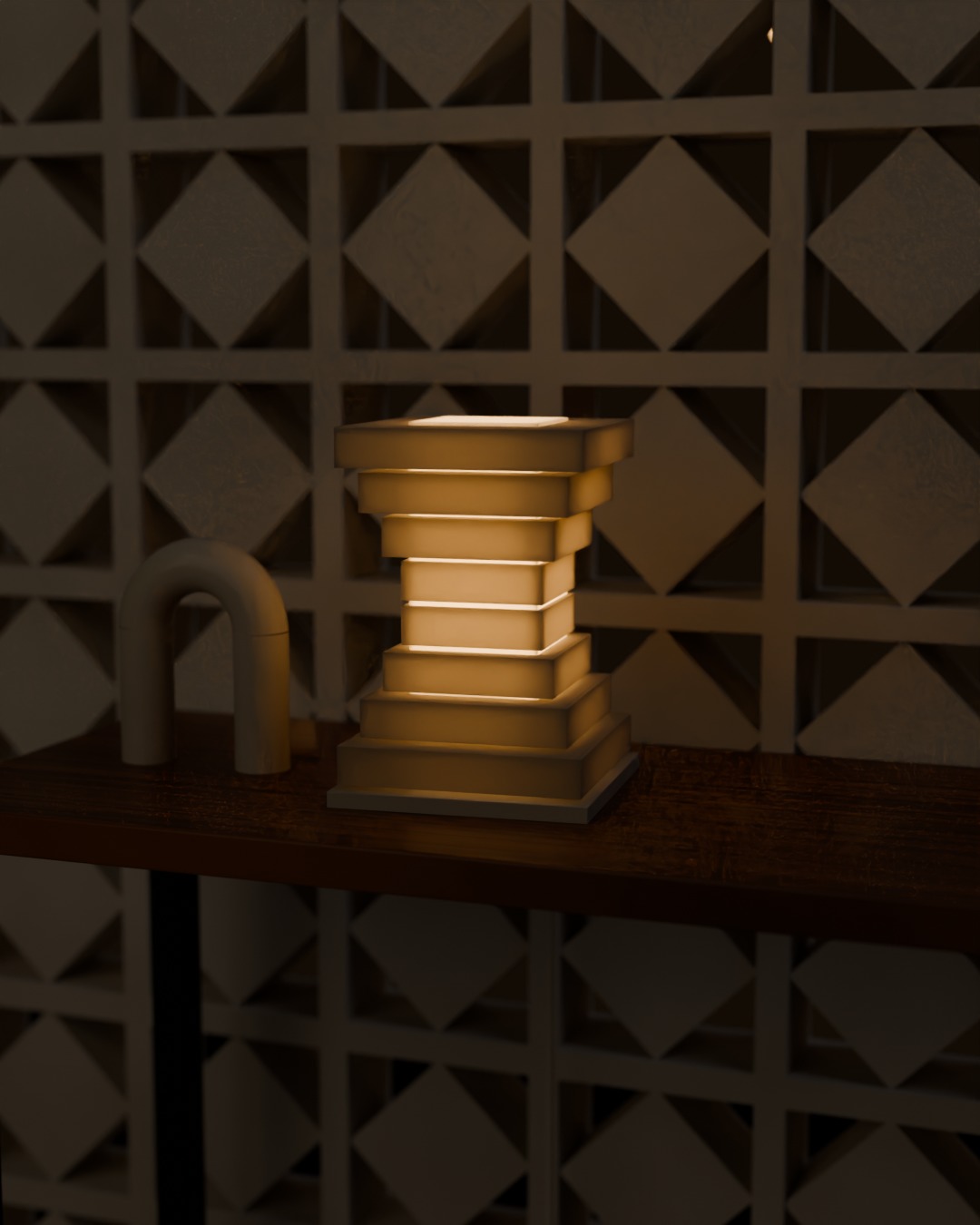 TINGKAT table lamp in bone white, switched on, against a breeze-block wall