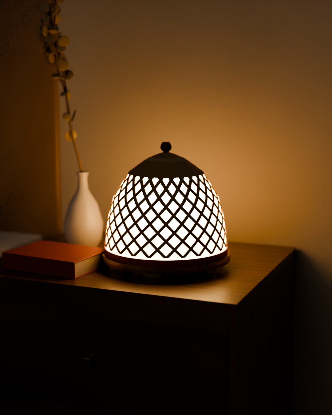 TUDUNG table lamp in bone, red and brass, switched on, on a bedside table